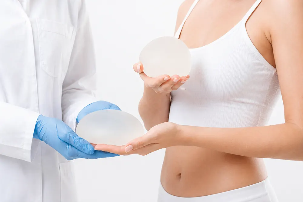 Breast augmentation consultation with breast implants at an aesthetic clinic showing size and shape options on a female patient